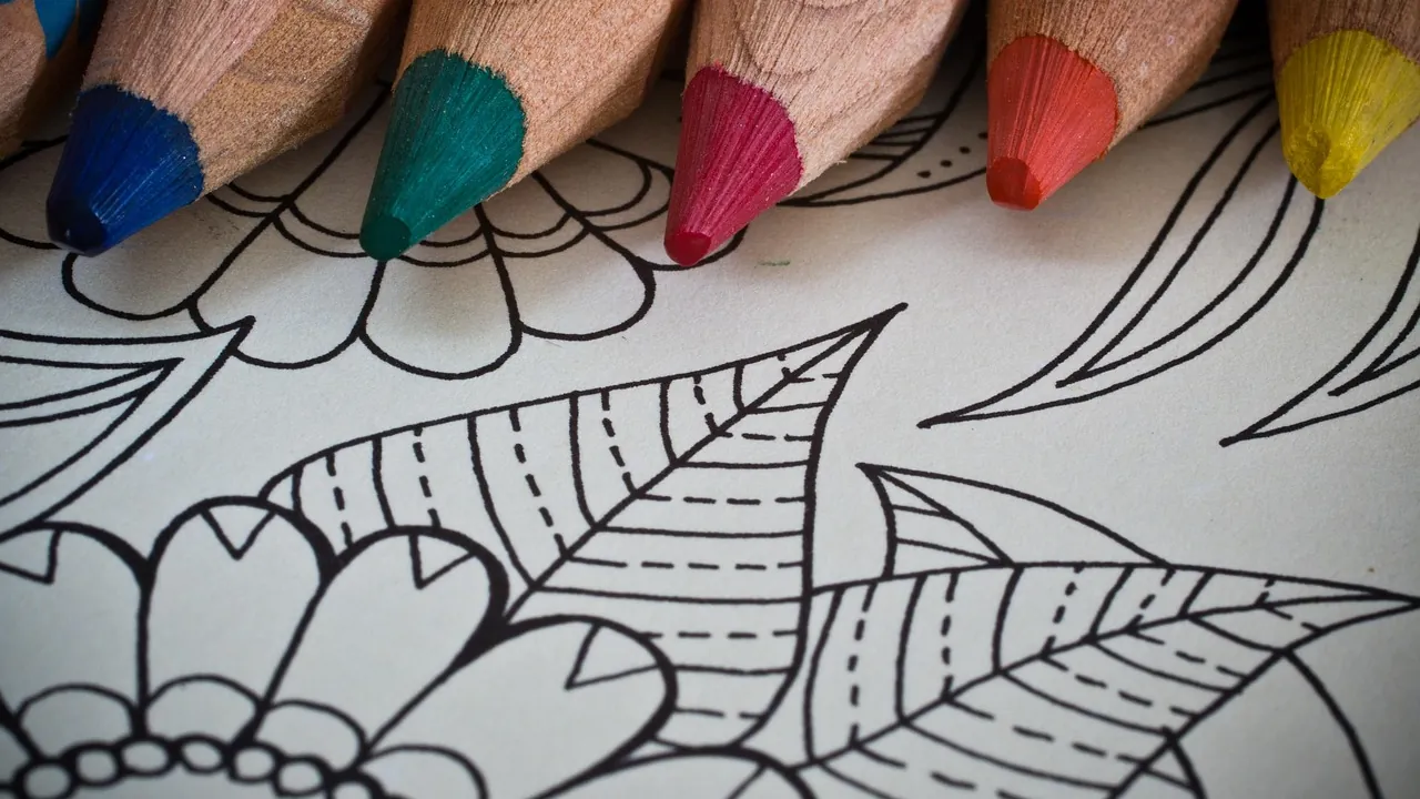 Crayons de couleur bleu, vert, rouge, orange et jaune sur une page à colorier