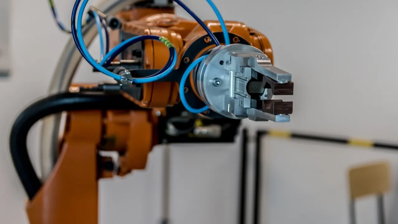 Bras robotisé orange d’une ligne de production automatisée