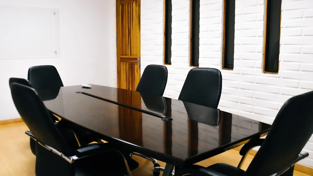 Table de réunion laquée noire entourée de fauteuils de direction