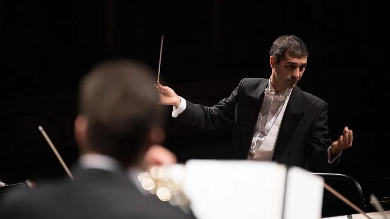 Chef d’orchestre dirigeant ses musiciens, baguette levée