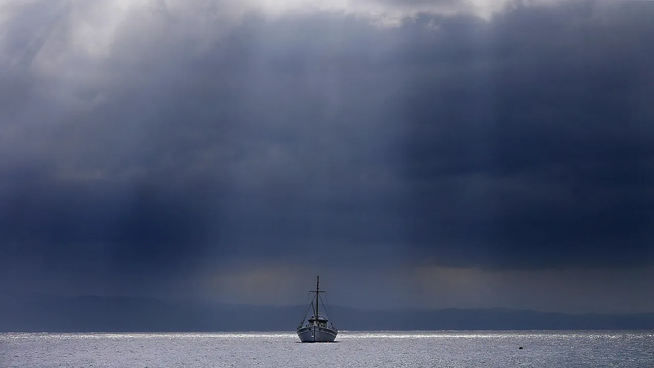 Petit bateau immobile sous un ciel d’orage chargé